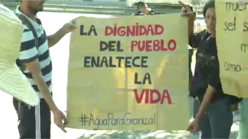 La imagen describe una pancarta que dice "la dignidad del pueblo, enaltece la vida" exhibida por damnificados de Granizal.