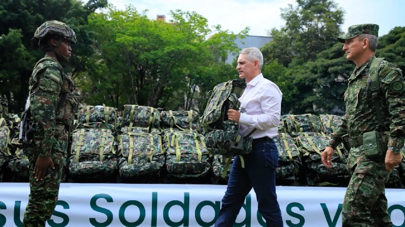 La imagen describe al Gobernador de Antioquia, Andrés Julián Rendón Cardona, entregando un morral de dotación a una soldado del Ejército Nacional