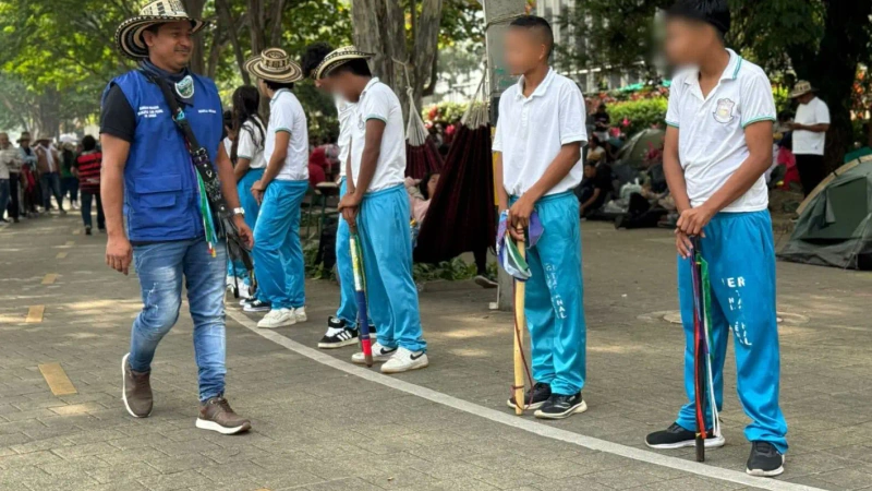 Unos 40 menores de edad, con uniformes escolares, conforman un escudo humano en el segundo día de minga indígena en Medellín. Foto: Teleantioquia.