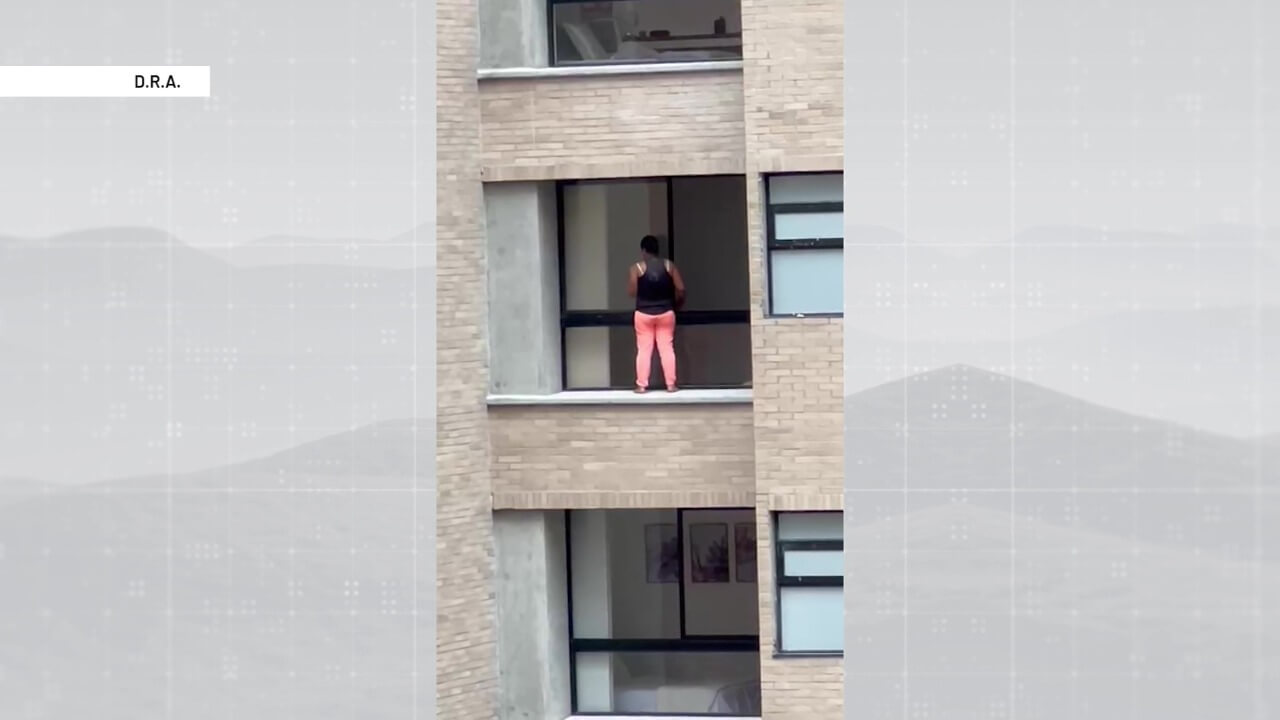 Mujer expone su vida para limpiar ventanas