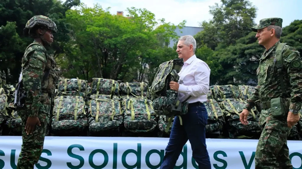 La imagen describe al Gobernador de Antioquia, Andrés Julián Rendón Cardona, entregando un morral de dotación a una soldado del Ejército Nacional